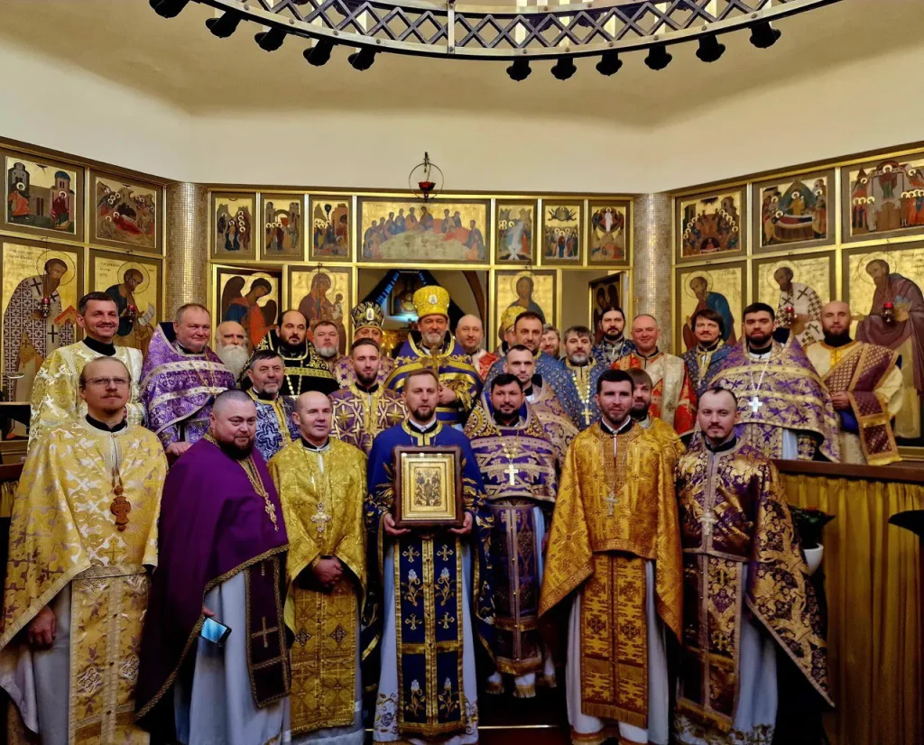Eine Gruppe Geistlicher in prächtigen, farbenprächtigen Gewändern steht beisammen in einer Kirche.